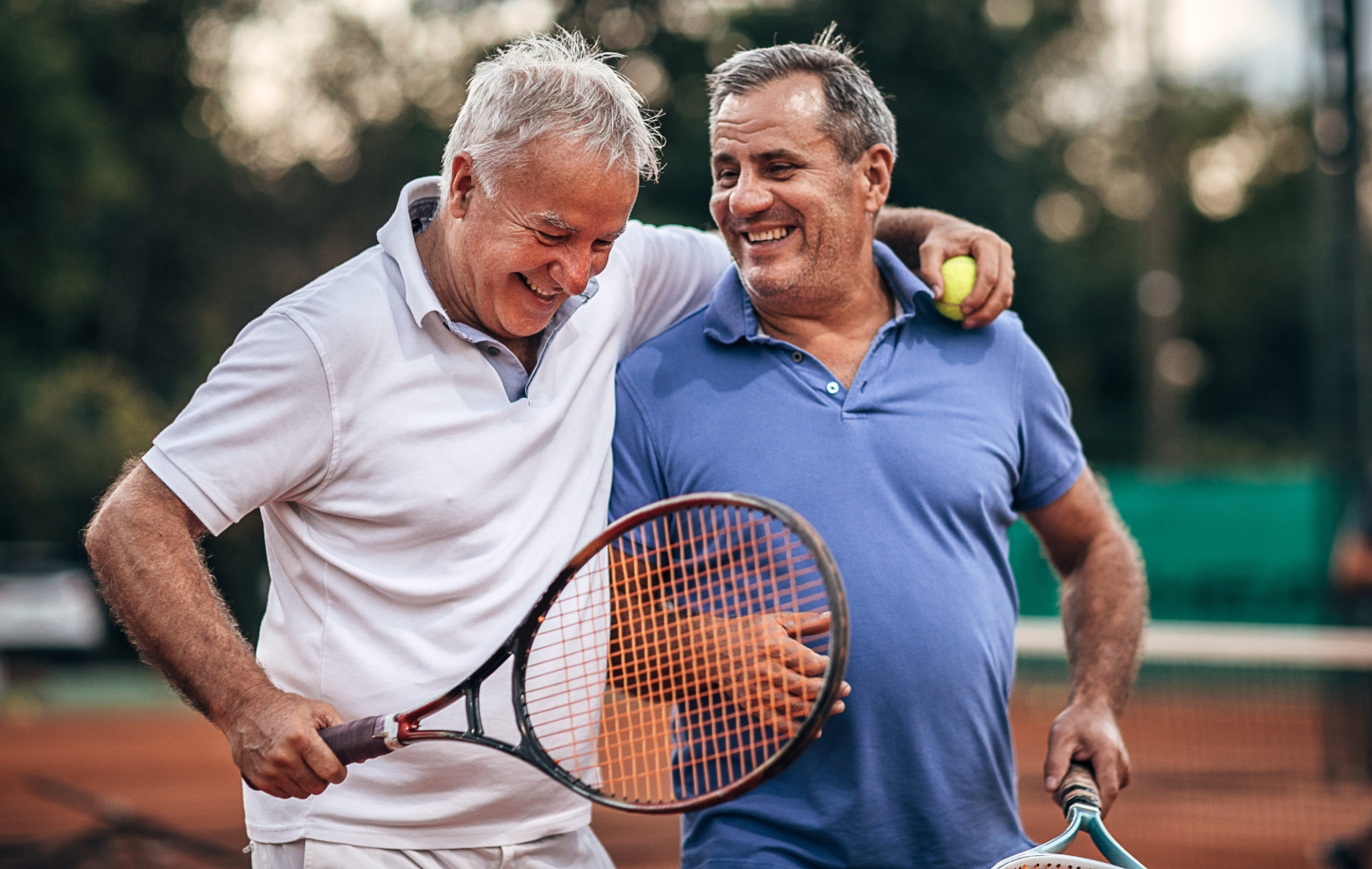 Two active, middle aged men, enjoying tennis